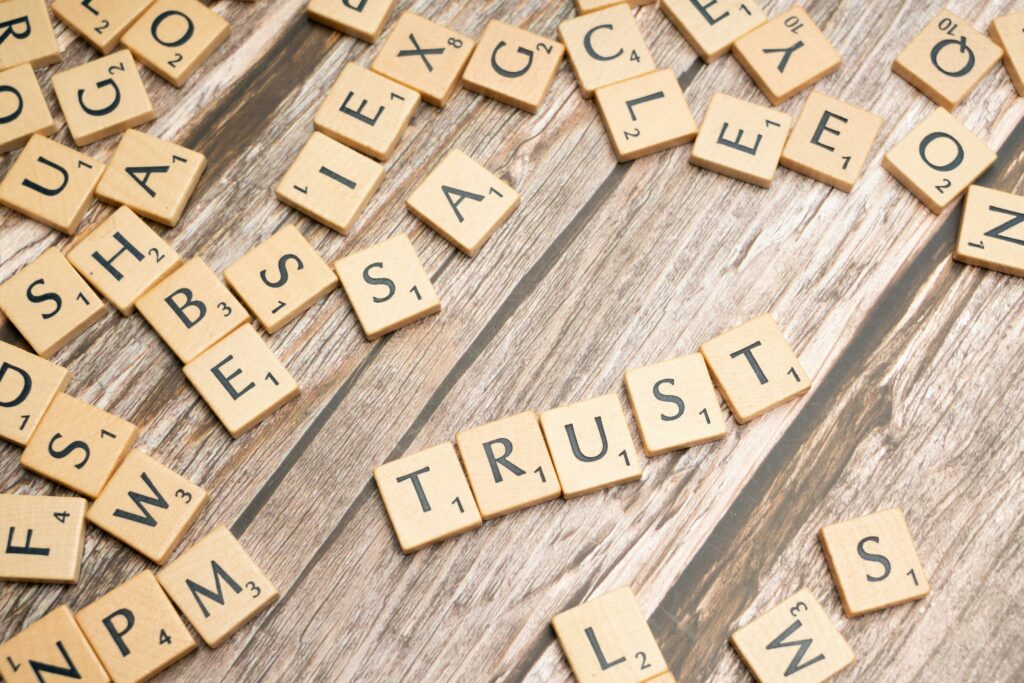 Scrabble-style letter blocks spelling out 'TRUST' on a wooden surface, symbolizing the foundation of honesty in real estate marketing