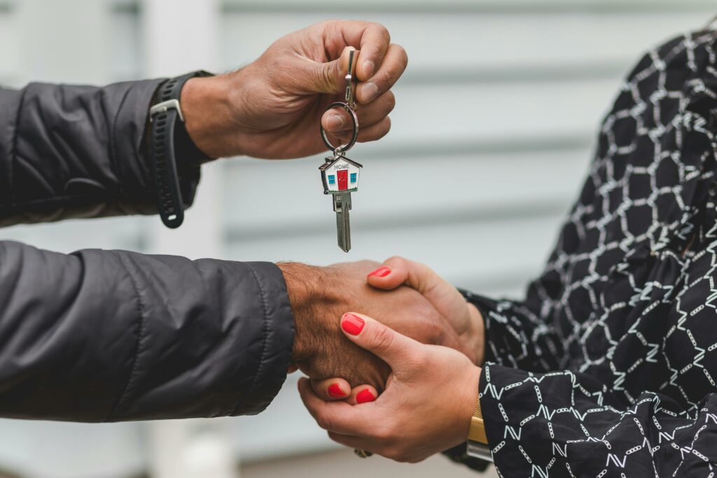 Man giving a woman house keys after selling the home, symbolizing successful real estate transactions.