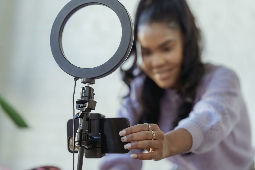 Happy young woman setting up smartphone before shooting video