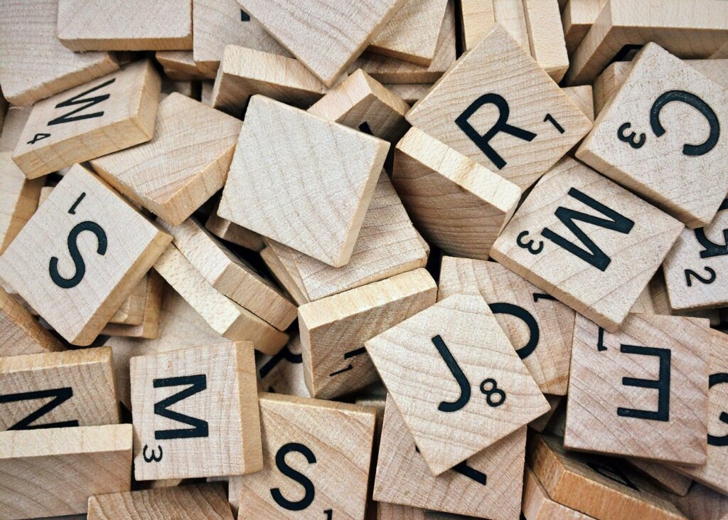 Scrabble letter tiles scattered on a wooden table, representing keywords