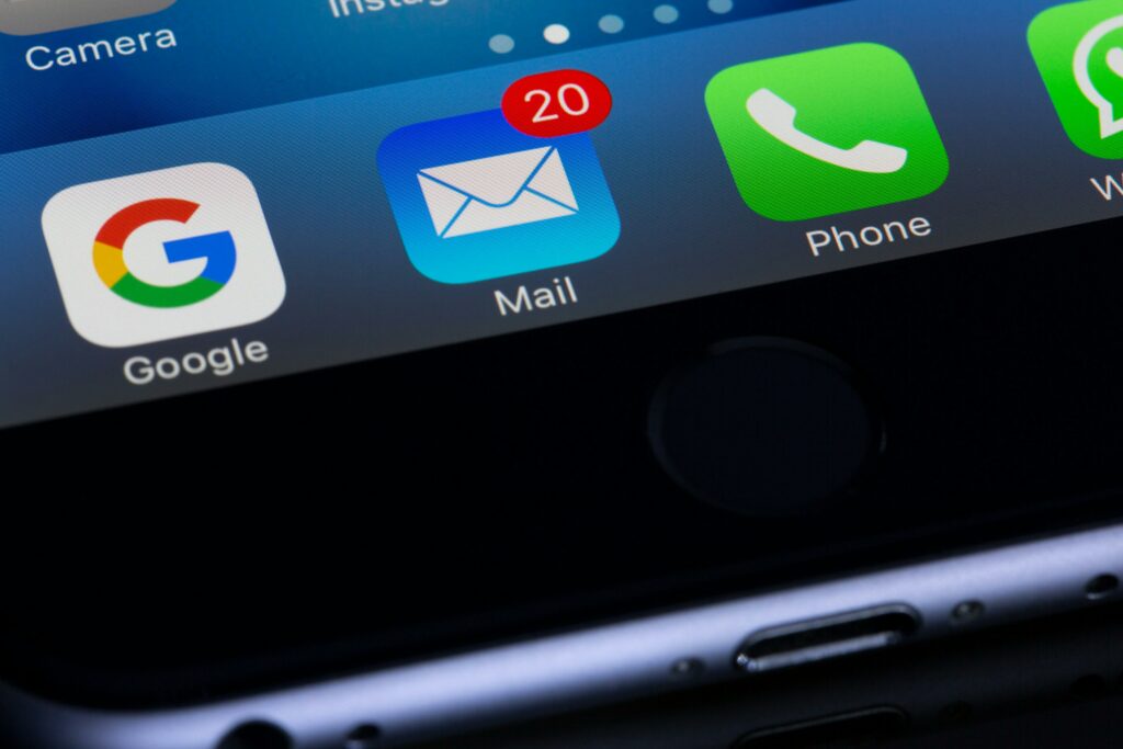 Closeup of a smartphone screen showing a mail inbox icon with unread messages, representing email inbox as a personal home base on the web perfect for real estate email campaigns.