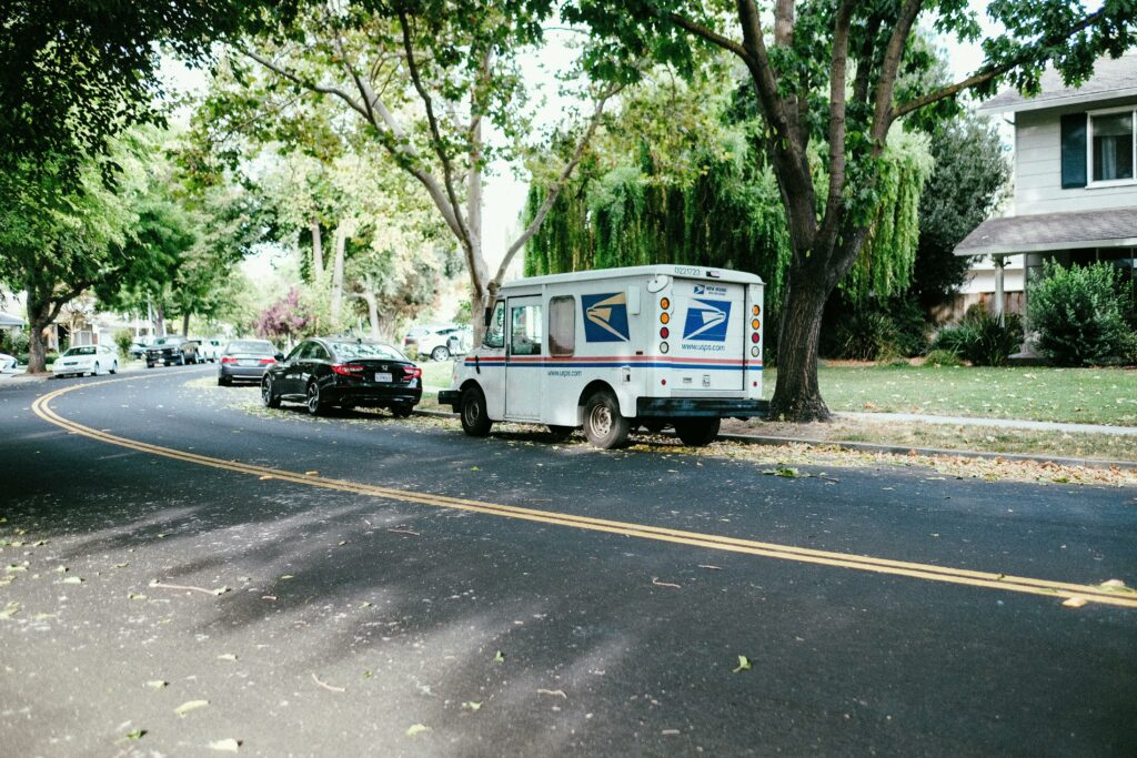 Postal service truck USPS in a real estate neighborhood full of homeowners and potential Realtor clients.