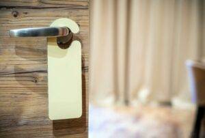 Blank door hanger for Realtors hangs on a wooden door to represent local real estate marketing for luxury agents by 23 Window Media