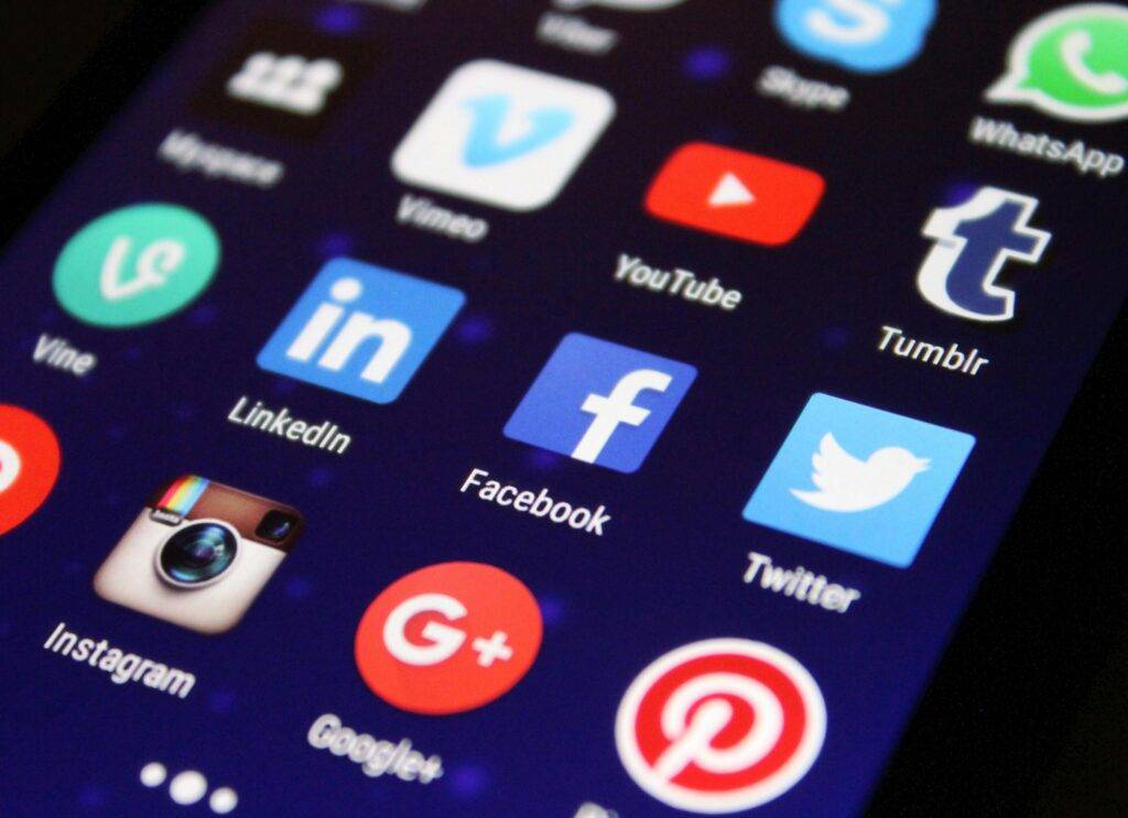 Smartphone screen showing social media app icons for digital real estate advertising to absentee homeowners