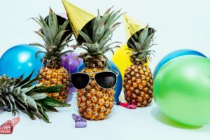 Pineapples dressed up like happy clients and raving fans celebrating together for real estate client referrals