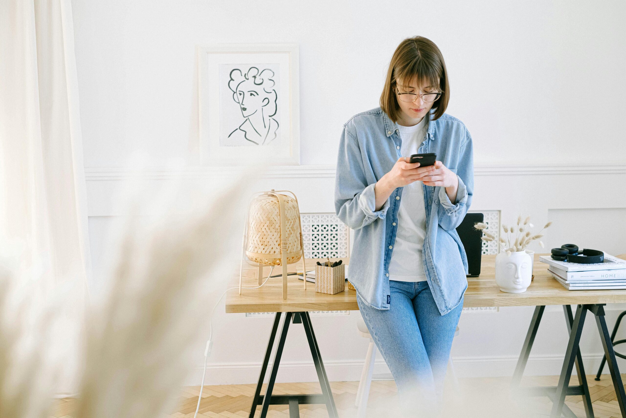 Woman looks at her smartphone to read an email newsletter for real estate agents and smart realtor marketing strategies