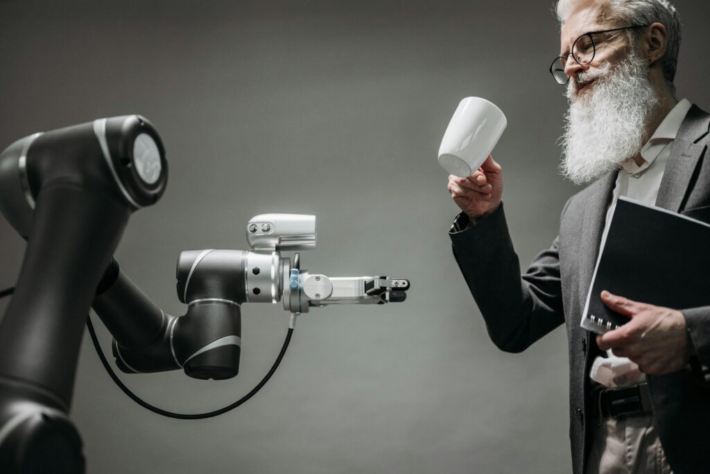 Bearded man handing a mug to a robot arm, representing the partnership between AI and real estate agents for marketing strategies