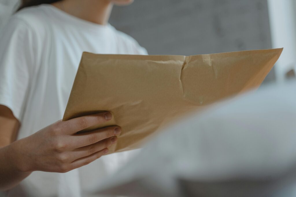 Person holding a mail package, representing cost-effective and successful mail marketing strategies for real estate agents.