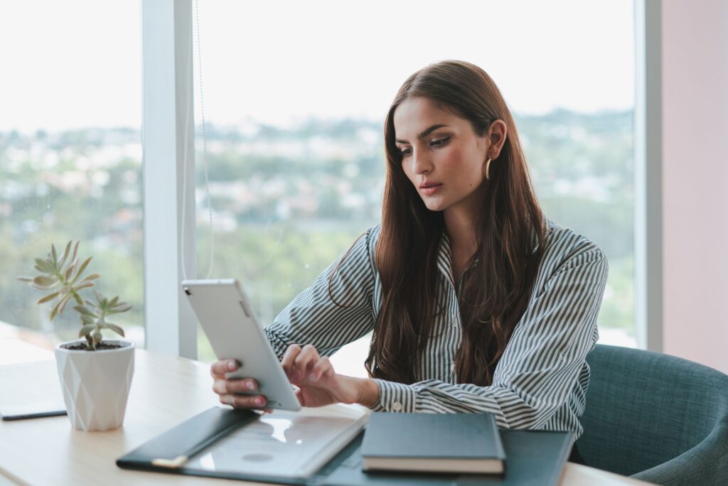 Woman in an office looks at a tablet computer for her real estate marketing on social media platforms