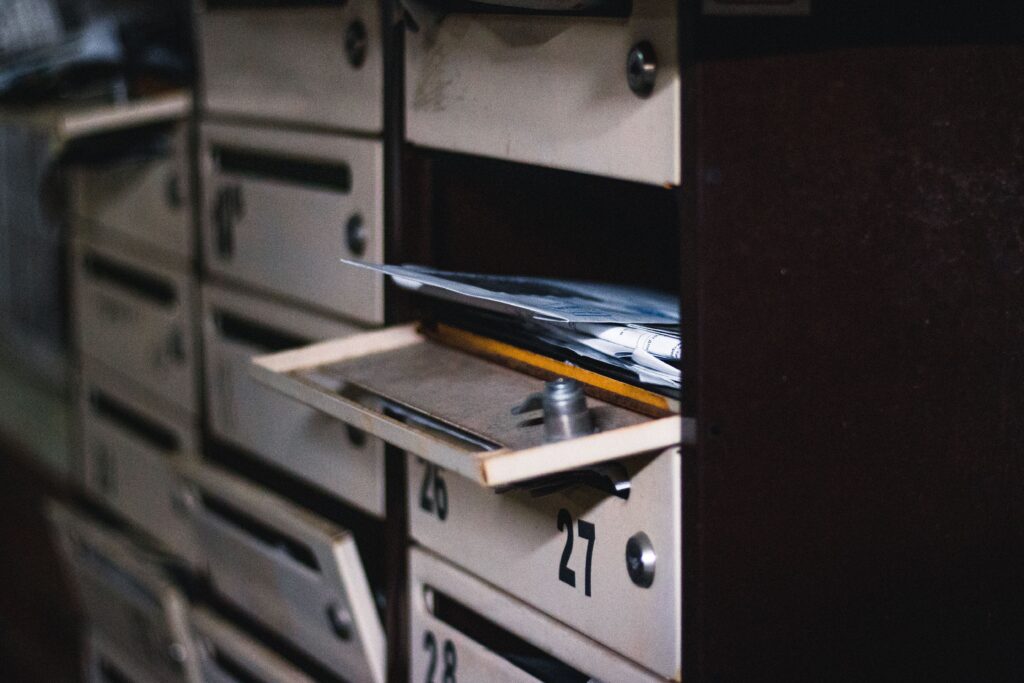 Mail in an open mailbox at a post office with rows of mailboxes, for print mail marketing by real estate agents to neighborhoods and local lead farming